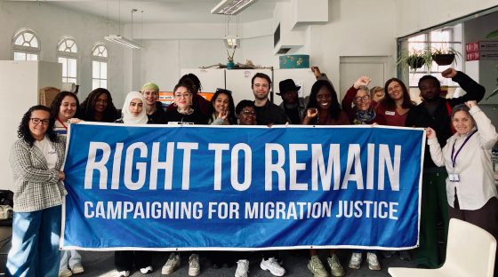 Picture shows Right to remain local solidarity session in Liverpool - a group of people are holding a banner saying 'Right to Remain campaigning for migration justice'
