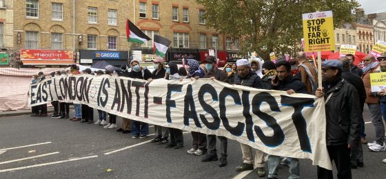 People hold a banner across a street which reads 'East London is Ant-Fascist'